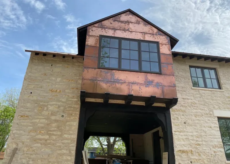 Copper metal panel facade on a stone building for Skylight Installation in Sitka